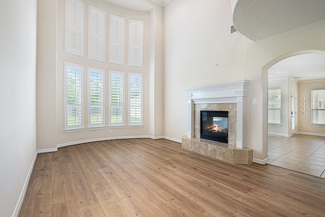 14414 Spring Mountain Dr, Tomball, TX 77377 - unfurnished living room with arched walkways, plenty of natural light, wood finished floors, and ornamental molding