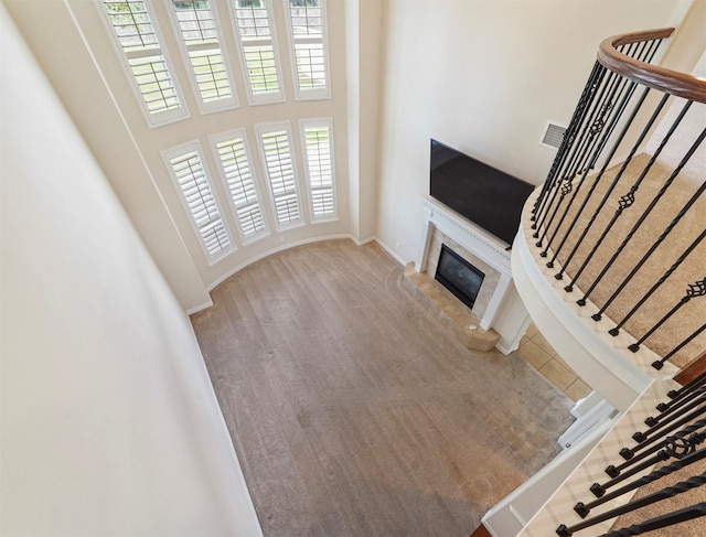 14414 Spring Mountain Dr, Tomball, TX 77377 - unfurnished living room featuring a high ceiling, carpet flooring, a high end fireplace, stairway, and baseboards