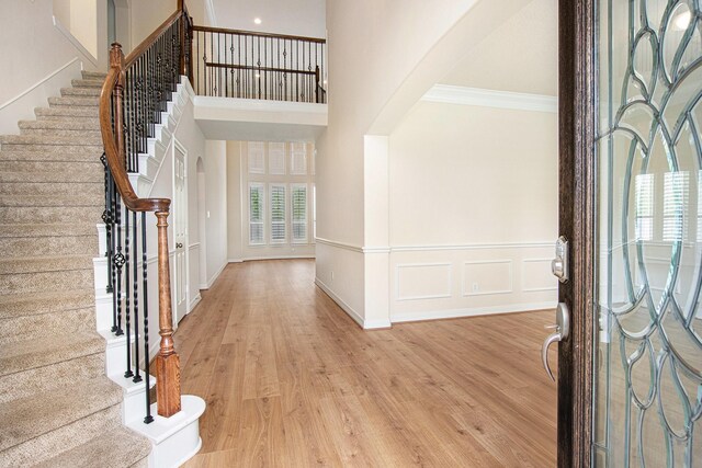 14414 Spring Mountain Dr, Tomball, TX 77377 - foyer entrance featuring stairway, light wood-type flooring, a high ceiling, and crown molding