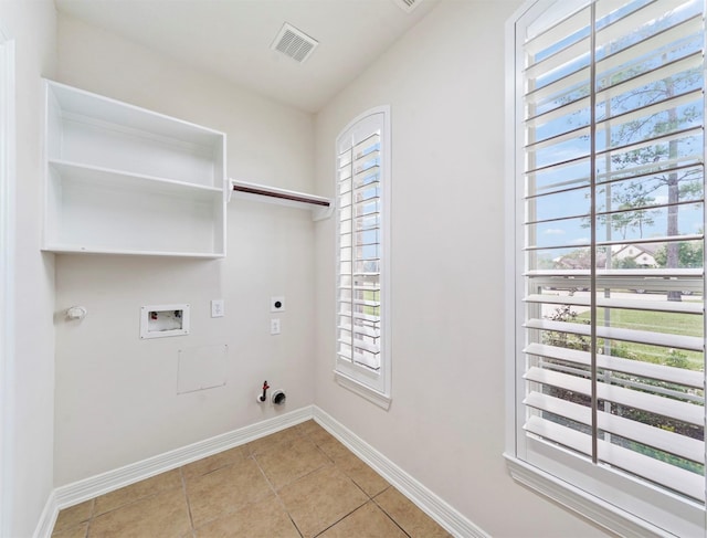 14414 Spring Mountain Dr, Tomball, TX 77377 - clothes washing area with gas dryer hookup, hookup for an electric dryer, hookup for a washing machine, light tile patterned floors, and baseboards