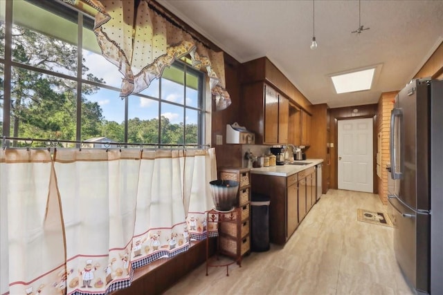 7760 Laurie Ln, Lumberton, TX 77657 - kitchen featuring stainless steel appliances, light countertops, brown cabinets, light wood-type flooring, and a sink