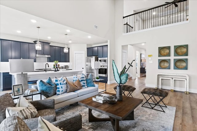 2213 Sonder Shore Dr, Katy, TX 77493 - living area featuring light wood finished floors, baseboards, recessed lighting, and a towering ceiling