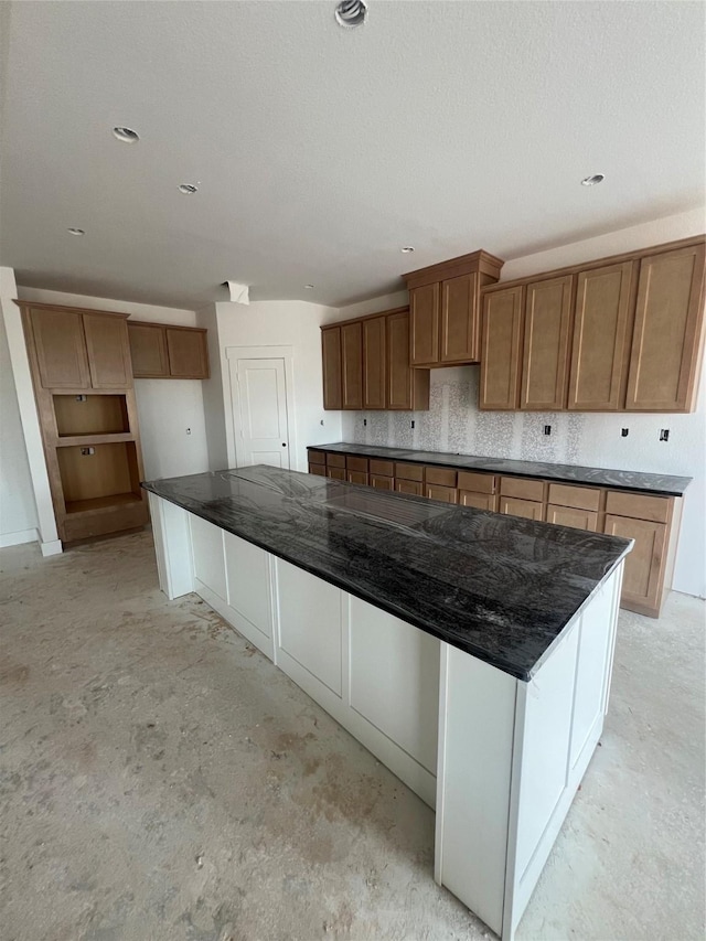 2213 Sonder Shore Dr, Katy, TX 77493 - kitchen with concrete flooring, brown cabinetry, and a spacious island