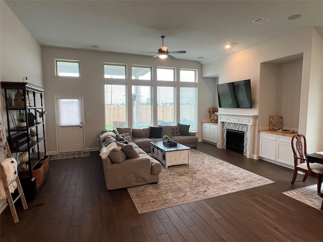 7426 Water Glen Ln, Manvel, TX 77578 - living room with ceiling fan, dark wood finished floors, a tiled fireplace, and baseboards