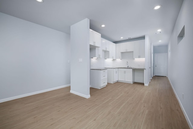 18834 Elegance Ave, Spring, TX 77379 - kitchen with baseboards, backsplash, light wood-style flooring, white cabinetry, and recessed lighting
