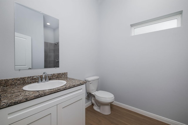 18834 Elegance Ave, Spring, TX 77379 - bathroom with wood finished floors, toilet, vanity, baseboards, and tiled shower