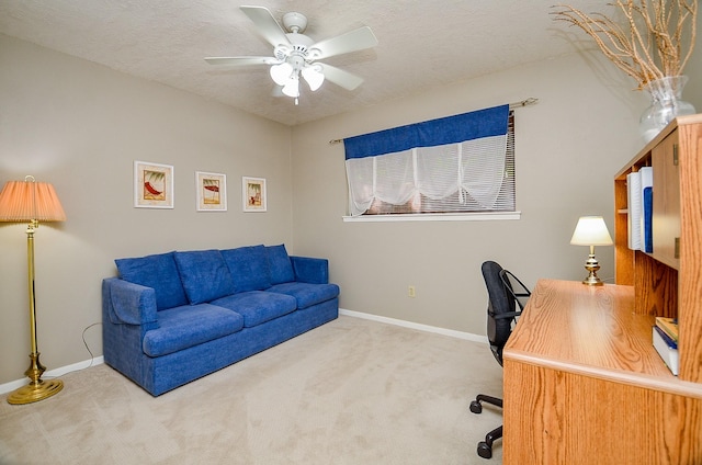 carpeted office with a ceiling fan, baseboards, and a textured ceiling