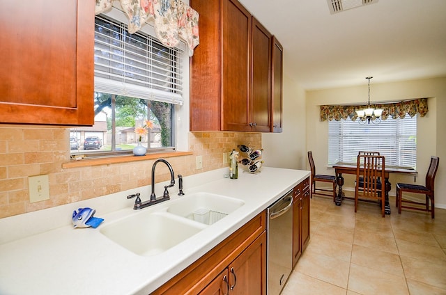 kitchen featuring stainless steel dishwasher, a sink, a chandelier, tasteful backsplash, and light tile patterned floors