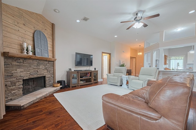 13203 Cary Ct, Needville, TX 77461 - living room with wood finished floors, ceiling fan, a stone fireplace, and recessed lighting