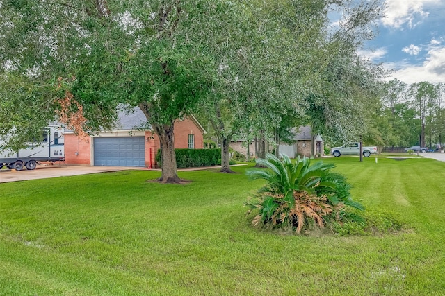 13203 Cary Ct, Needville, TX 77461 - view of grassy yard with driveway and a garage