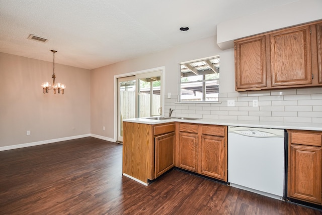 5809 Village Forest Ct, Houston, TX 77092 - kitchen with white dishwasher, brown cabinets, a chandelier, a sink, and decorative backsplash
