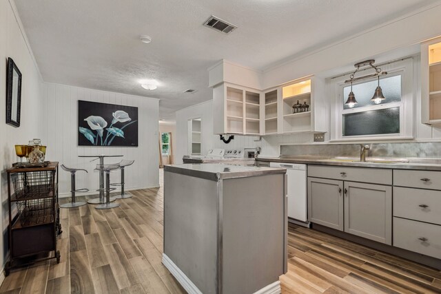 507 Silverdale Dr, Conroe, TX 77301 - kitchen featuring dishwasher, open shelves, wood finished floors, and a center island