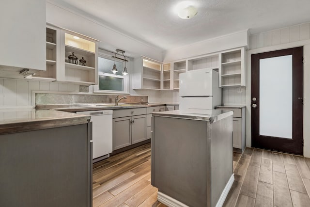 507 Silverdale Dr, Conroe, TX 77301 - kitchen featuring open shelves, white appliances, gray cabinetry, wood finished floors, and a textured ceiling