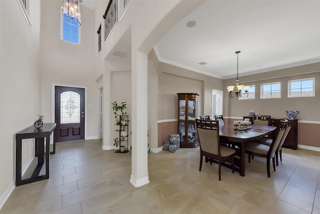 entrance foyer featuring a chandelier, arched walkways, baseboards, light tile patterned floors, and ornamental molding
