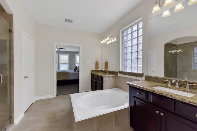 ensuite bathroom featuring healthy amount of natural light, a shower stall, a whirlpool tub, and a chandelier