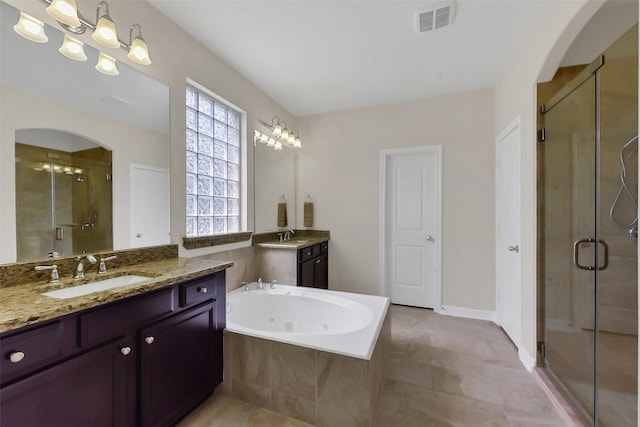 bathroom with a shower stall, a whirlpool tub, and two vanities