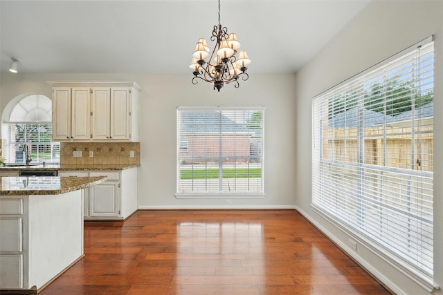 4027 Austin Meadow Dr, Sugar Land, TX 77479 - kitchen featuring dark wood-style floors, a chandelier, light stone countertops, and hanging light fixtures