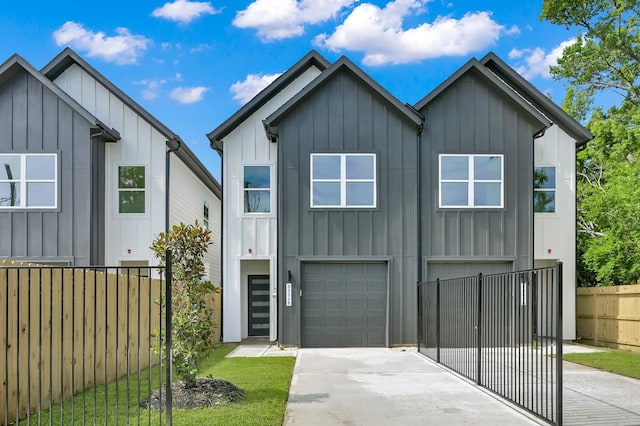 view of front of house with board and batten siding, a garage, concrete driveway, and fence