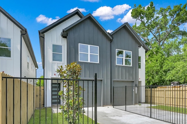 view of property exterior with board and batten siding, concrete driveway, a garage, and fence