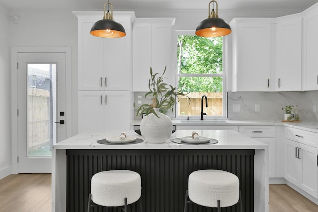 kitchen featuring a sink, light wood-style flooring, a breakfast bar area, and a center island