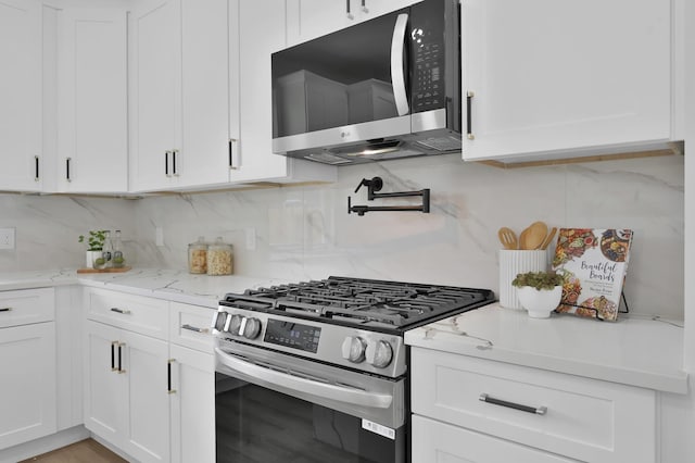 kitchen featuring appliances with stainless steel finishes, white cabinets, and backsplash