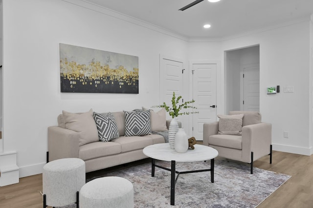 living room with light wood-style flooring, ornamental molding, a ceiling fan, baseboards, and recessed lighting