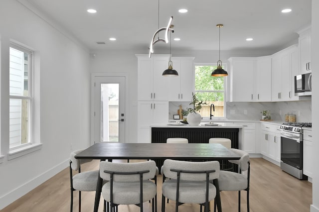 kitchen featuring stainless steel appliances, white cabinetry, light wood-type flooring, light countertops, and recessed lighting