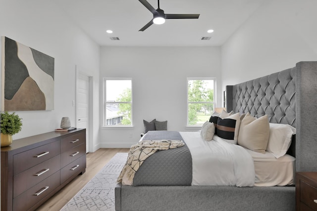bedroom featuring multiple windows, light wood finished floors, a ceiling fan, baseboards, and recessed lighting