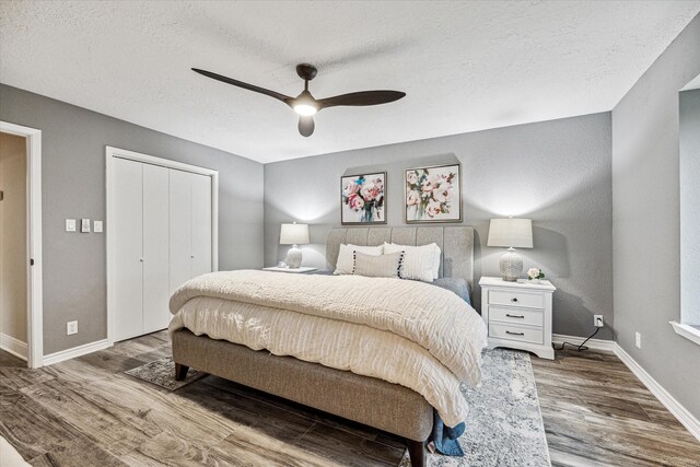 20316 County Road 510b, Brazoria, TX 77422 - bedroom with wood finished floors, baseboards, a closet, a textured ceiling, and a ceiling fan