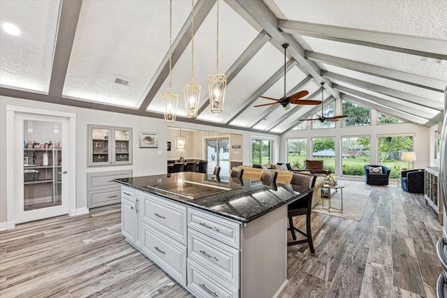 20316 County Road 510b, Brazoria, TX 77422 - kitchen featuring open floor plan, white cabinetry, a center island, light wood-type flooring, and beamed ceiling