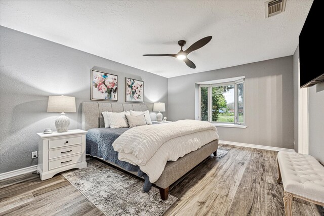 20316 County Road 510b, Brazoria, TX 77422 - bedroom with wood finished floors, baseboards, ceiling fan, and a textured ceiling