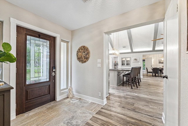 20316 County Road 510b, Brazoria, TX 77422 - foyer featuring wood finished floors, a chandelier, baseboards, and a textured ceiling