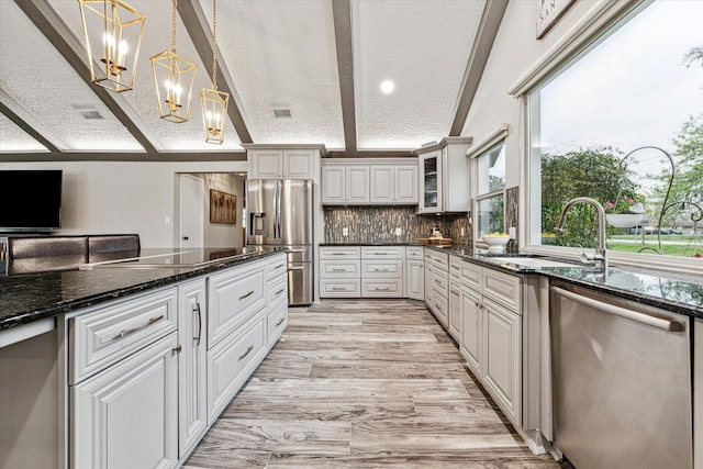20316 County Road 510b, Brazoria, TX 77422 - kitchen with appliances with stainless steel finishes, a textured ceiling, a sink, a chandelier, and glass insert cabinets