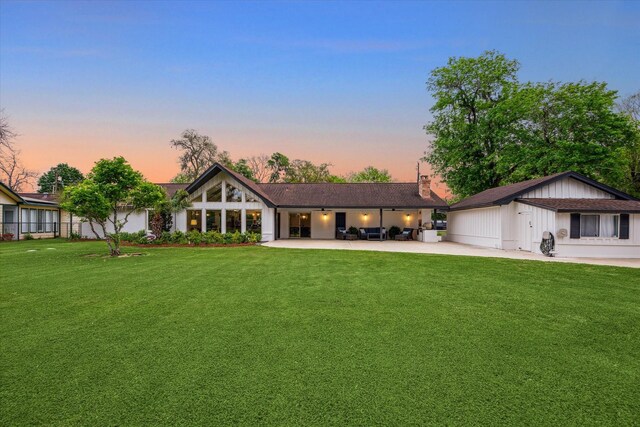 20316 County Road 510b, Brazoria, TX 77422 - view of front of house featuring a front yard, a patio area, an attached garage, and a chimney