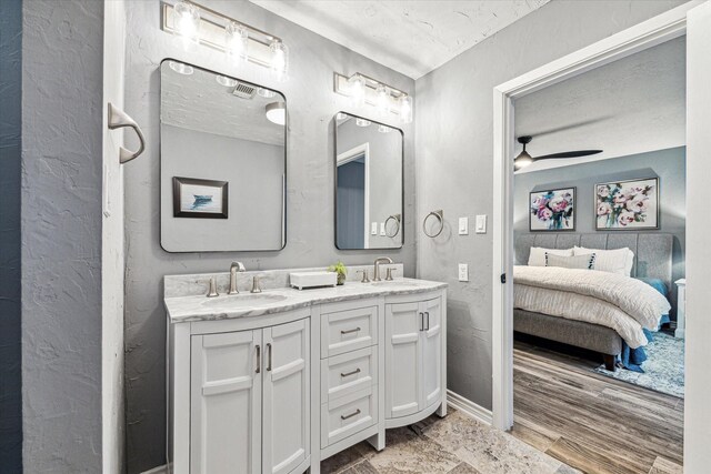 20316 County Road 510b, Brazoria, TX 77422 - full bath with connected bathroom, double vanity, ceiling fan, a textured ceiling, and wood finished floors