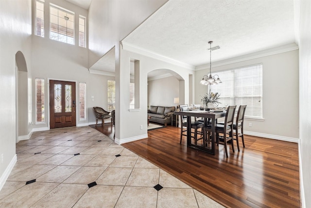 11405 Starlight Bay St, Pearland, TX 77584 - tiled entryway with arched walkways, baseboards, healthy amount of natural light, crown molding, and a textured ceiling