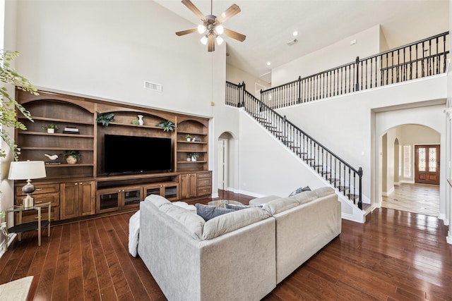 11405 Starlight Bay St, Pearland, TX 77584 - living room featuring arched walkways, a high ceiling, dark wood-style floors, stairway, and ceiling fan