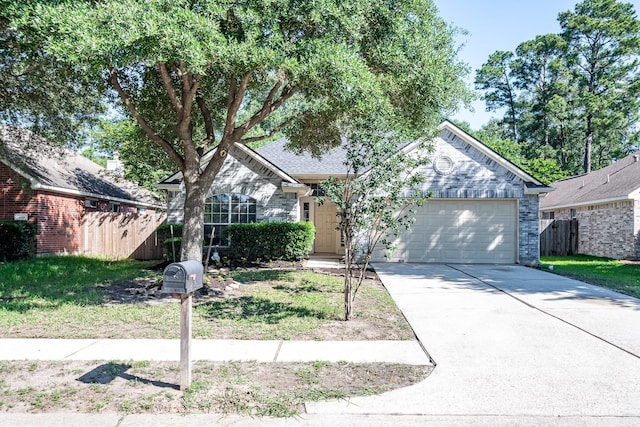 4523 Bridgevillage Dr, Spring, TX 77373 - view of front of house featuring a garage, driveway, fence, and stone siding