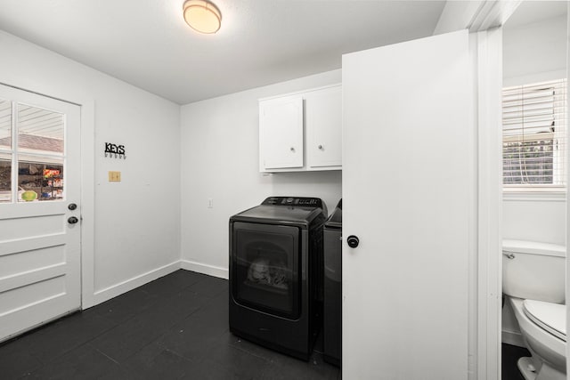 13919 Kimberley Ln, Houston, TX 77079 - laundry area with washing machine and clothes dryer, plenty of natural light, baseboards, and dark tile patterned flooring
