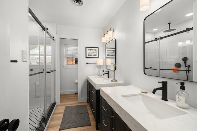 13919 Kimberley Ln, Houston, TX 77079 - full bath featuring a shower stall, two vanities, wood finished floors, and baseboards