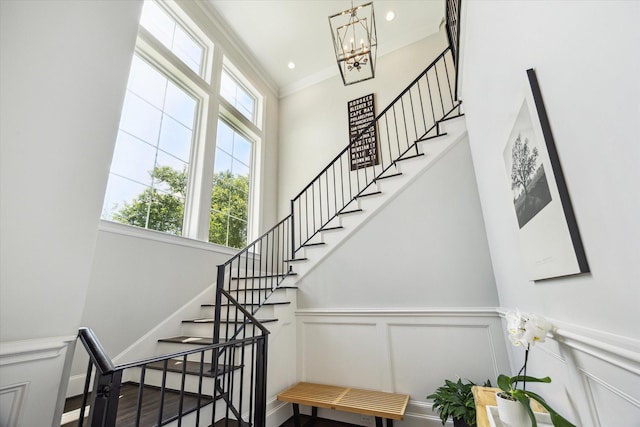 3912 Browning St, West University Place, TX 77005 - stairs with a decorative wall, a chandelier, a high ceiling, crown molding, and wainscoting