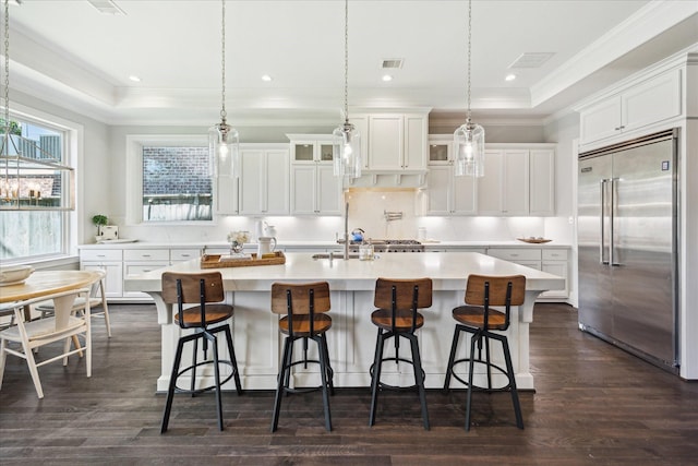 3912 Browning St, West University Place, TX 77005 - kitchen with built in refrigerator, ornamental molding, light countertops, dark wood-style flooring, and white cabinetry
