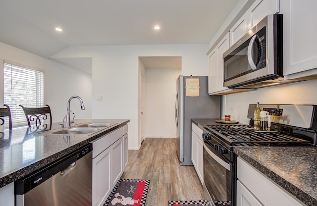 kitchen with appliances with stainless steel finishes, a sink, white cabinets, light wood finished floors, and recessed lighting