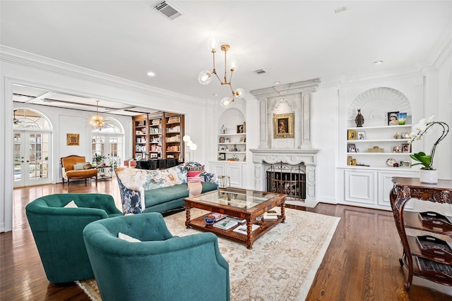 853 Rocky River Rd, Houston, TX 77056 - living area featuring built in shelves, ornamental molding, dark wood finished floors, a large fireplace, and a chandelier