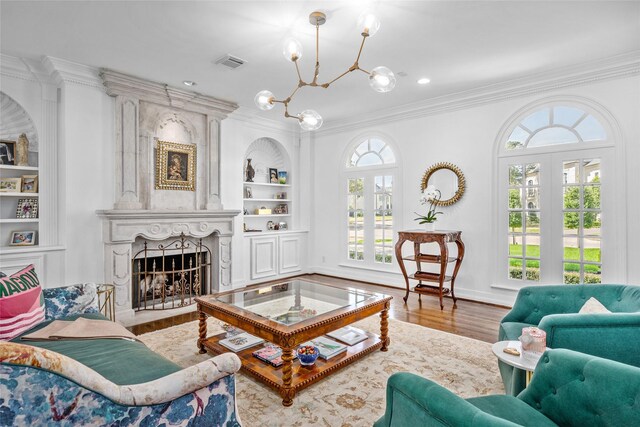 853 Rocky River Rd, Houston, TX 77056 - living area featuring a chandelier, ornamental molding, built in features, wood finished floors, and a fireplace