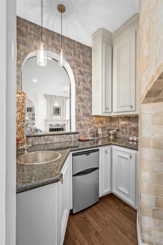 853 Rocky River Rd, Houston, TX 77056 - kitchen with a sink, dark wood-type flooring, arched walkways, white cabinets, and pendant lighting