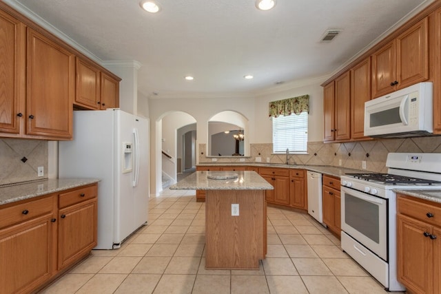 5227 Sandyfields Ln, Katy, TX 77494 - kitchen with white appliances, arched walkways, a sink, a center island, and ornamental molding