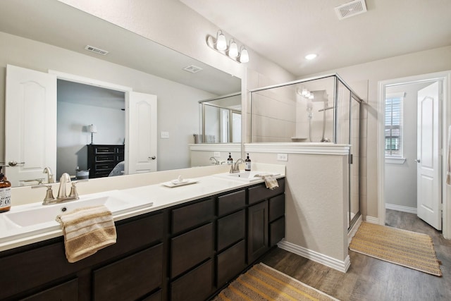 15863 Sundew Prairie Dr, Humble, TX 77346 - ensuite bathroom with a stall shower, double vanity, wood finished floors, and baseboards
