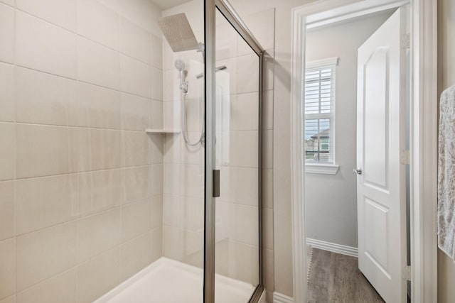 15863 Sundew Prairie Dr, Humble, TX 77346 - full bathroom featuring a stall shower, baseboards, and wood finished floors