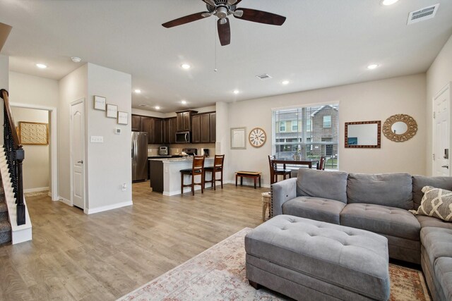 15863 Sundew Prairie Dr, Humble, TX 77346 - living room with a ceiling fan, light wood-style flooring, recessed lighting, baseboards, and stairway